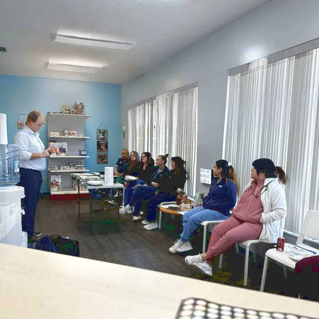 Staff training in the light and airy waiting room, with full-length windows on one side. A selection of products available to purchase are showcased at one end of the room and a water cooler is available for public use.